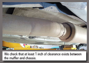 We check for at least 1 inch clearance exists between the muffler and chassis